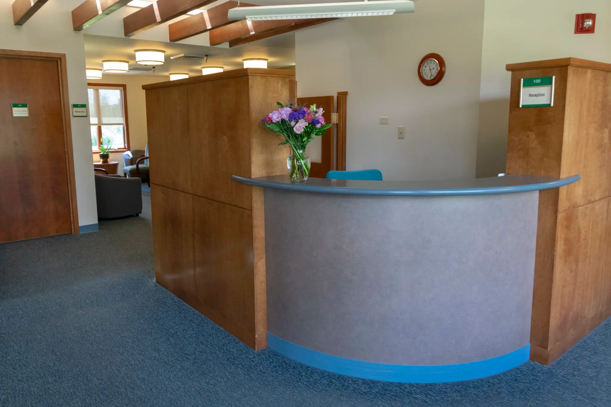 Reception desk with flowers in a bright facility lobby