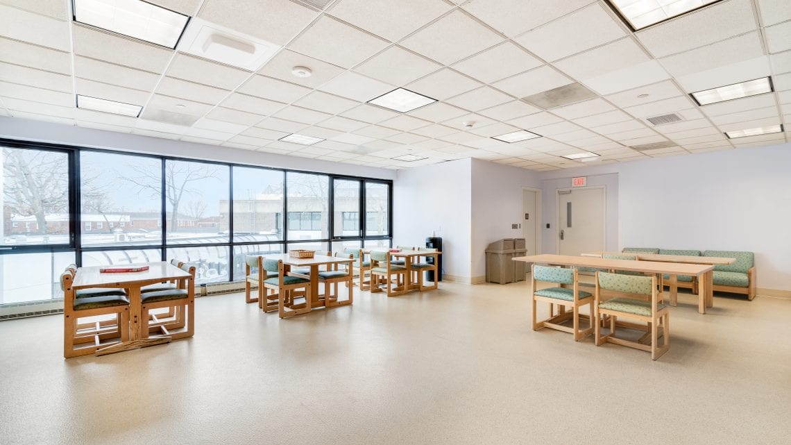 Dining space with tables, benches, and large windows