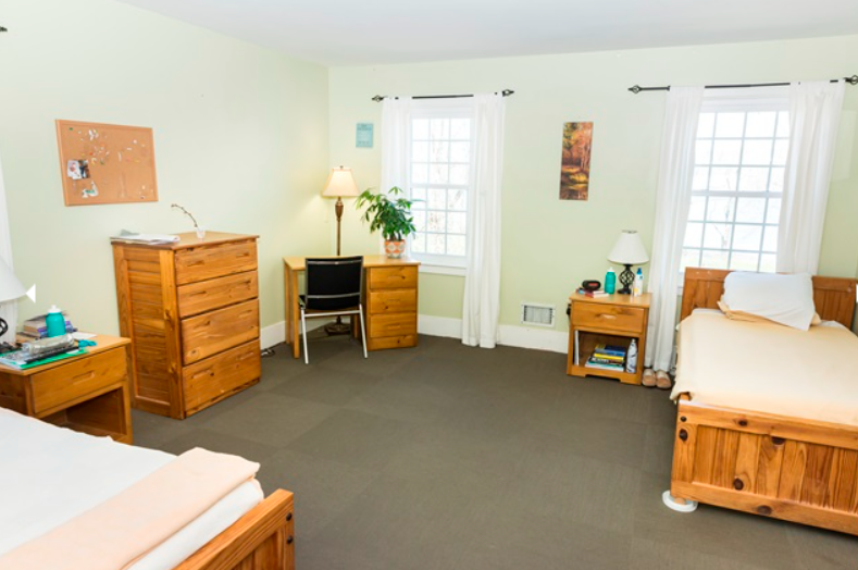 Bright shared bedroom with twin beds and wood furniture