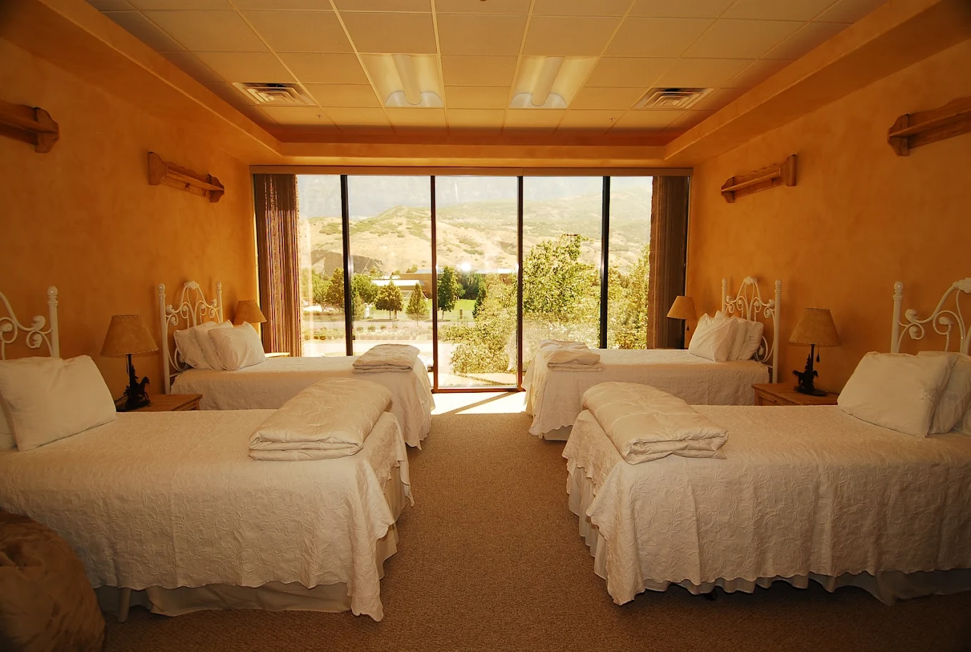 Warm-toned shared bedroom with four beds and mountain view