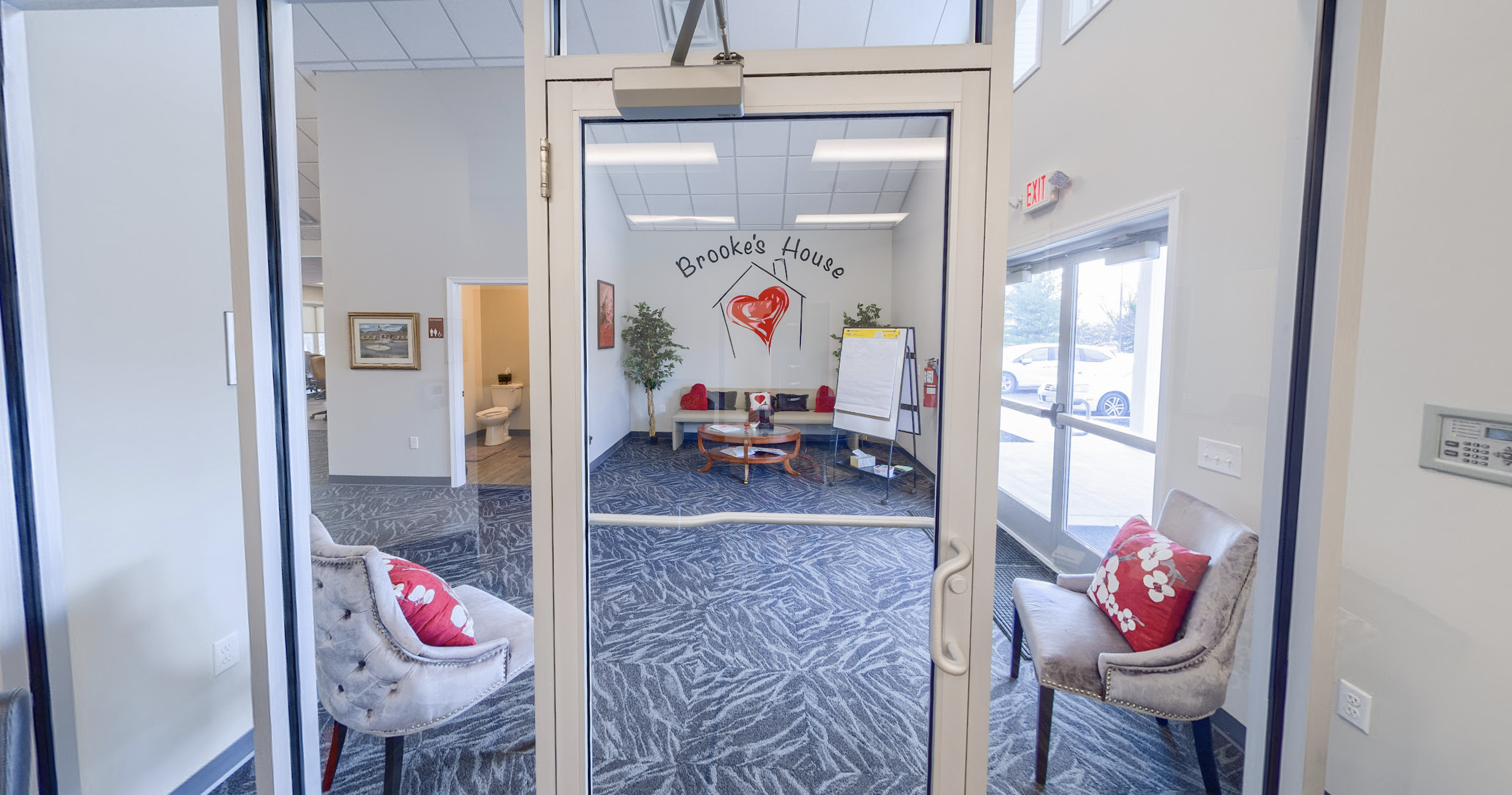 Glass entrance doors opening into a carpeted lobby