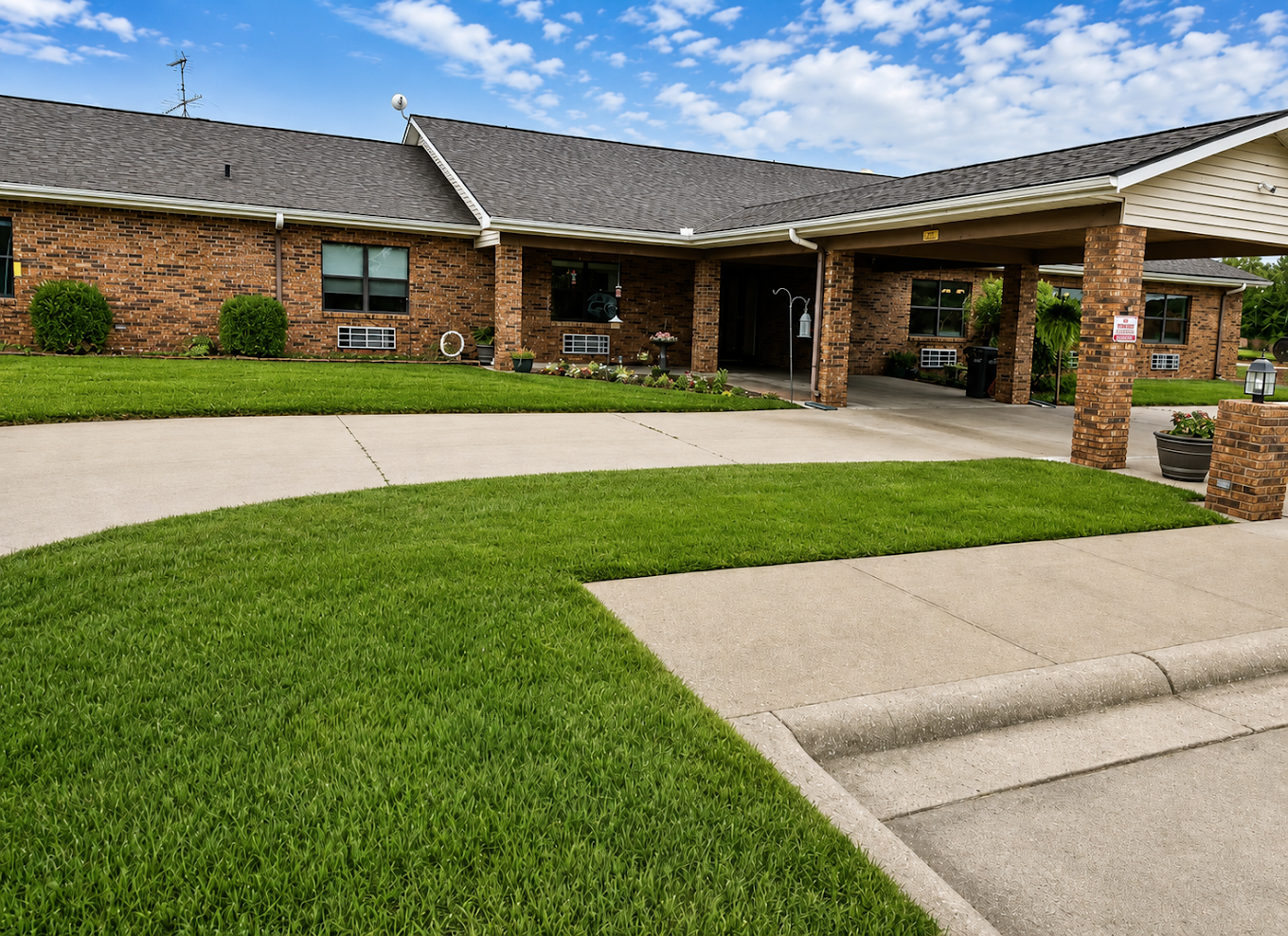 Landscaped courtyard with green lawn and covered walkway