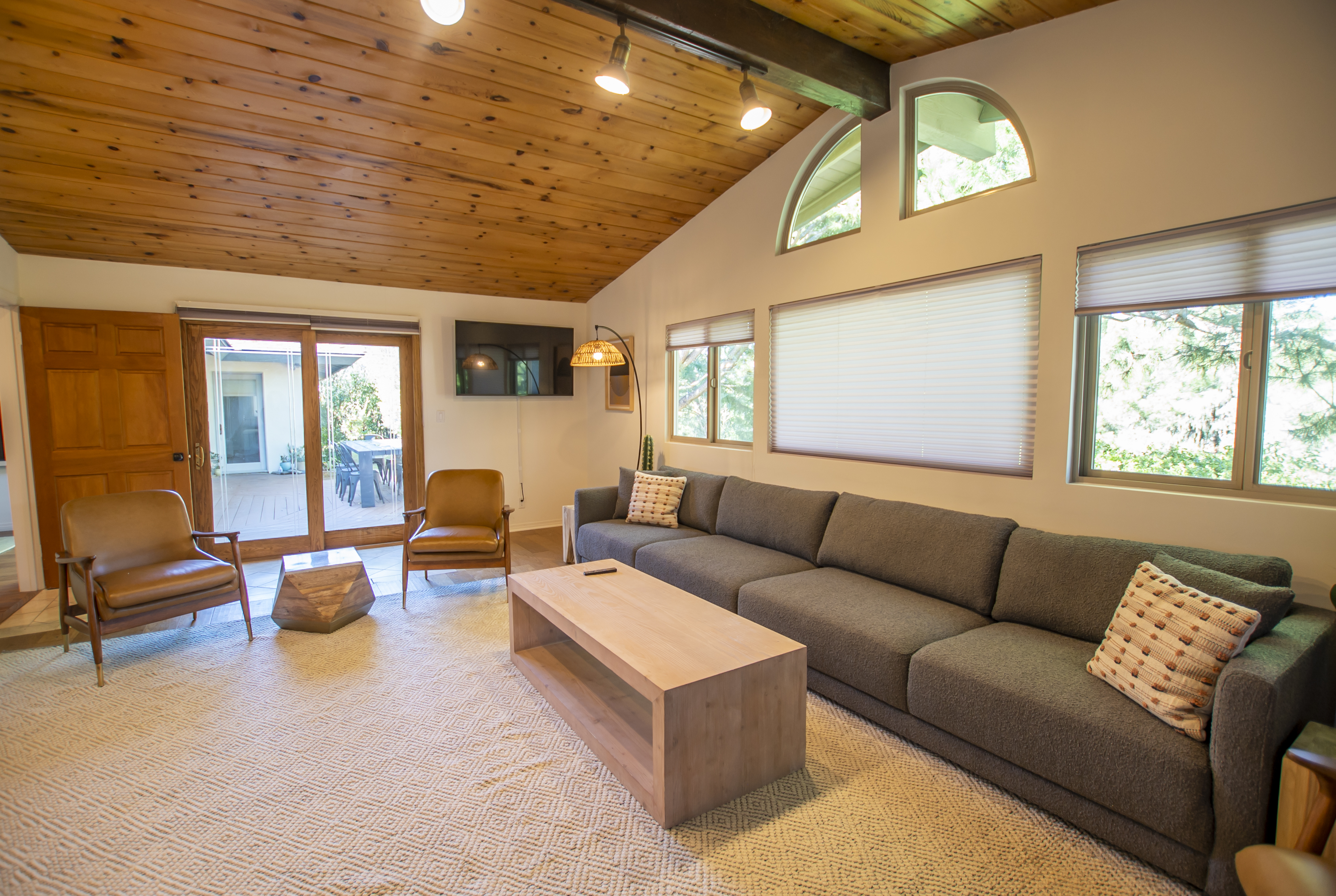 Large gray couch under wood-paneled ceiling