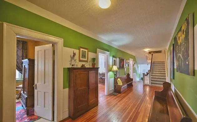 Long hallway with green walls and wood floors