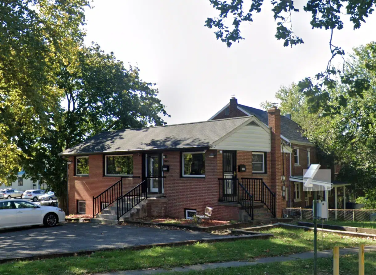 Brick clinic building with stairs and parking area outside