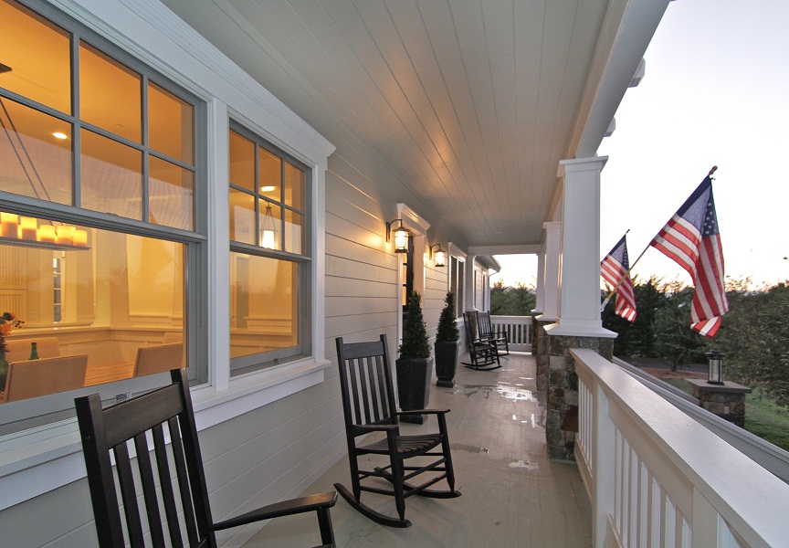 Porch with chairs and flags on columns.