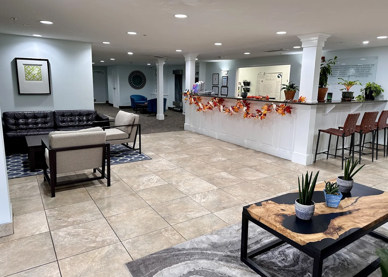 Spacious reception area with seasonal décor, modern furnishings, and front desk at New Roads Behavioral Health