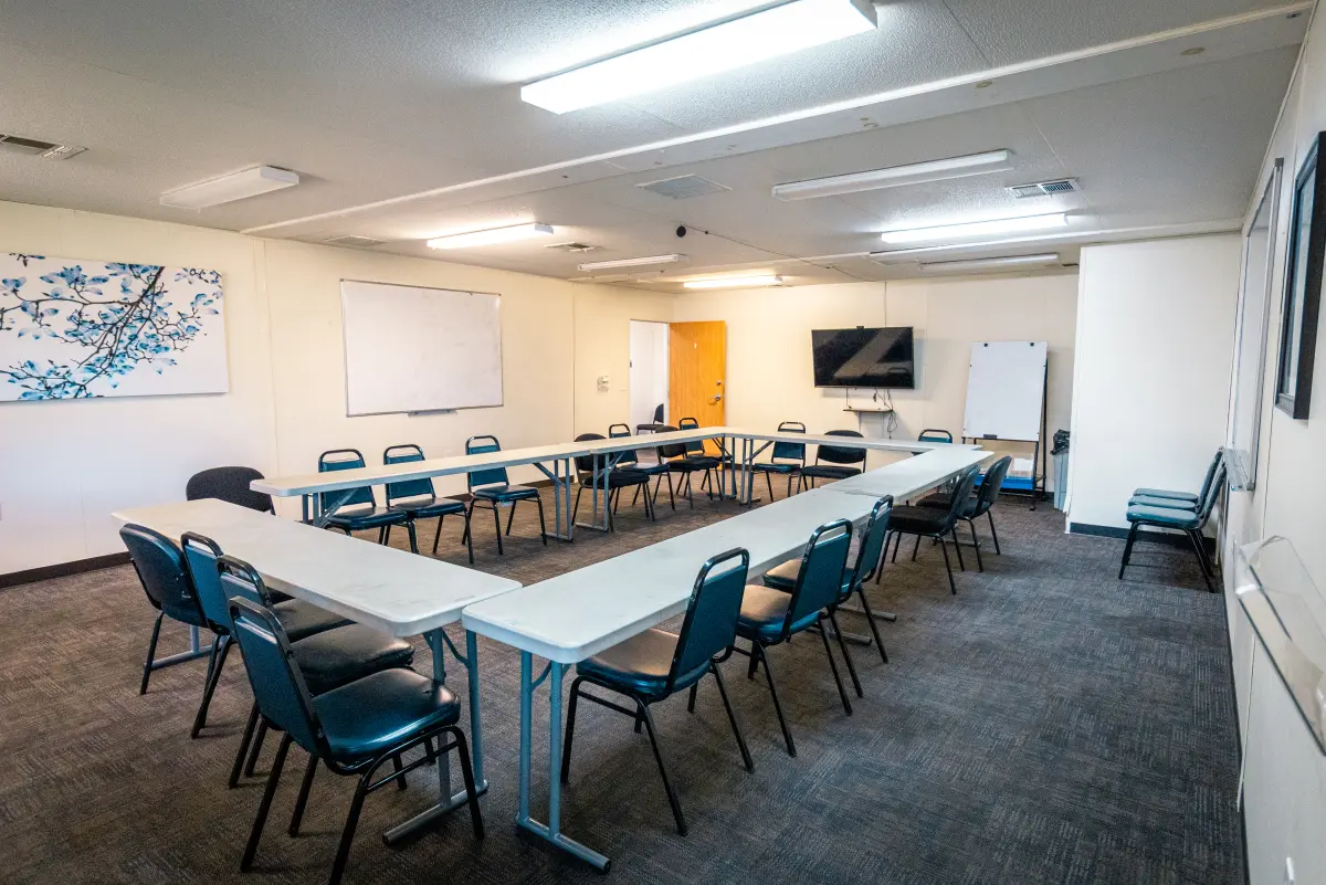 Group therapy room with chairs and tables in U shape