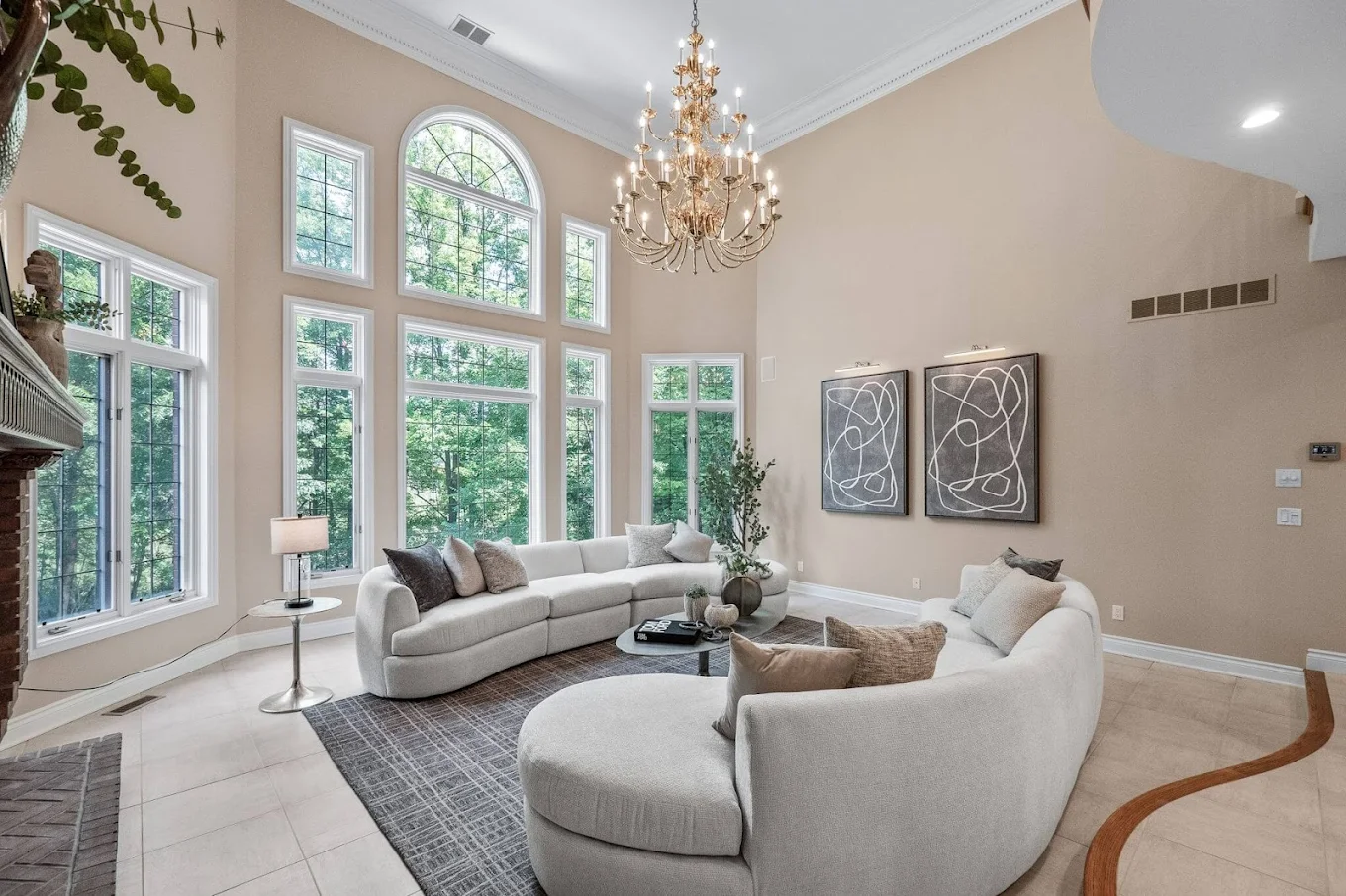 Large windows and couches in a high-ceiling living room