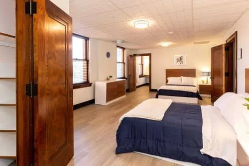 Two beds in a warmly lit room with modern wood decor