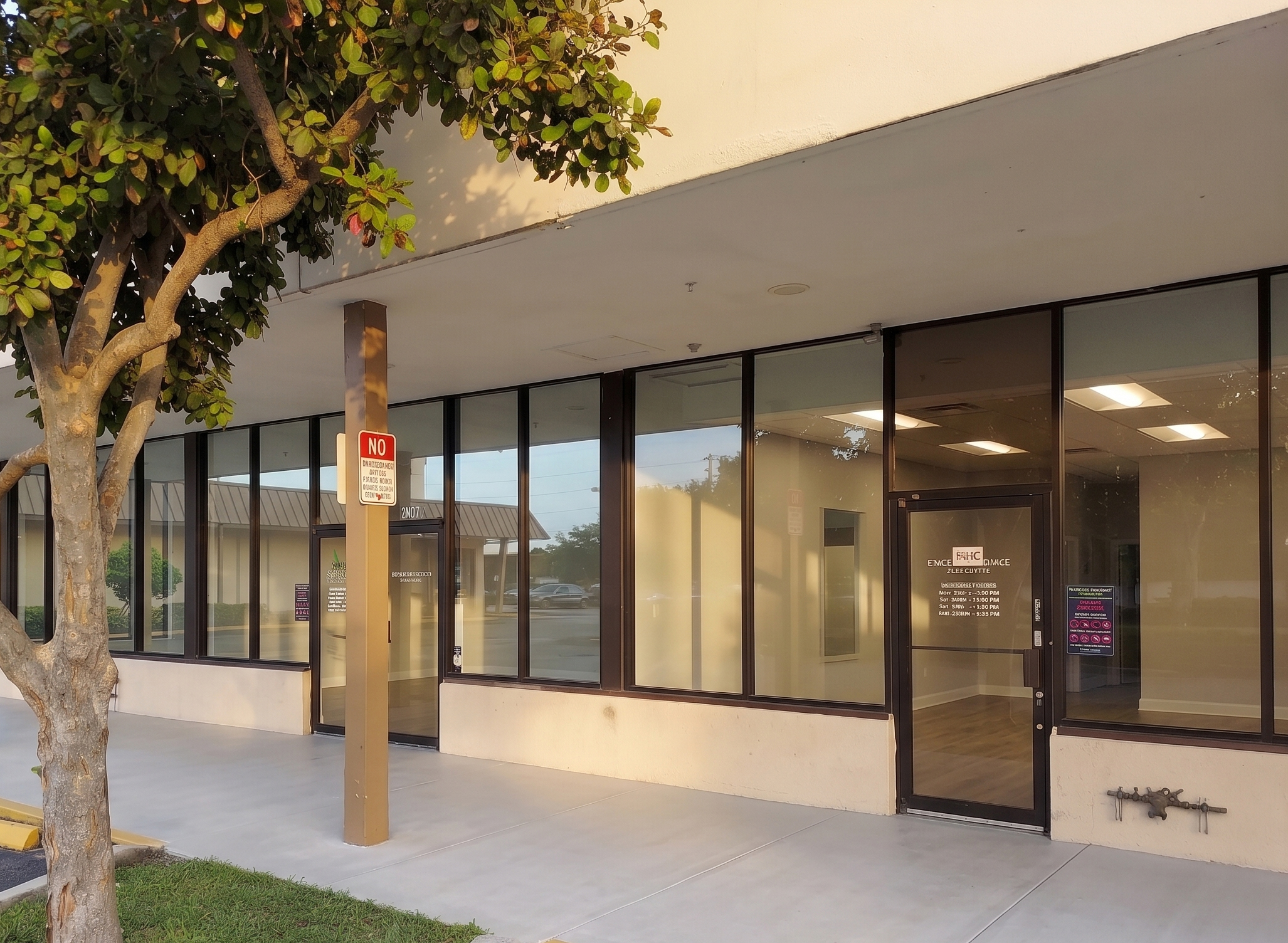 Facility entrance with glass doors, windows, and covered walkway