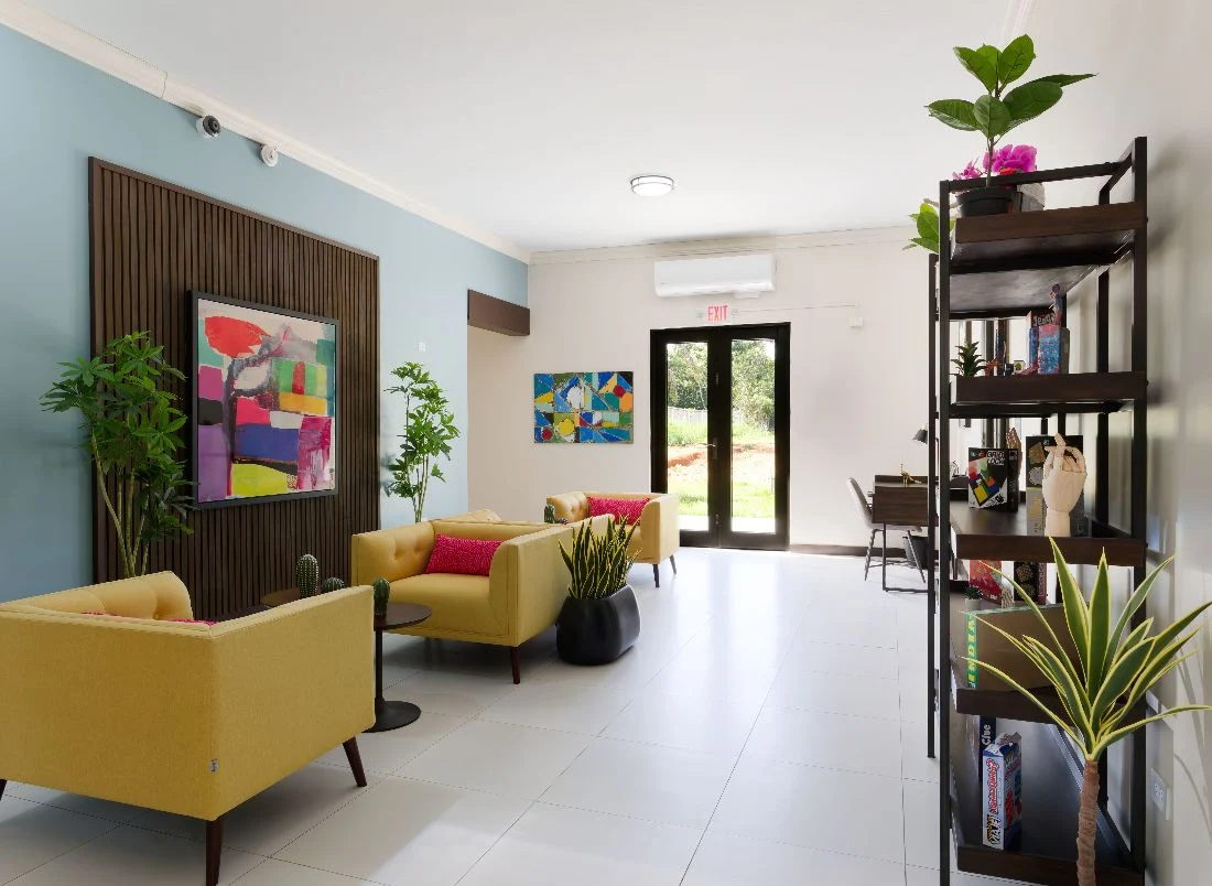 Colorful welcome lounge with yellow chairs and plants