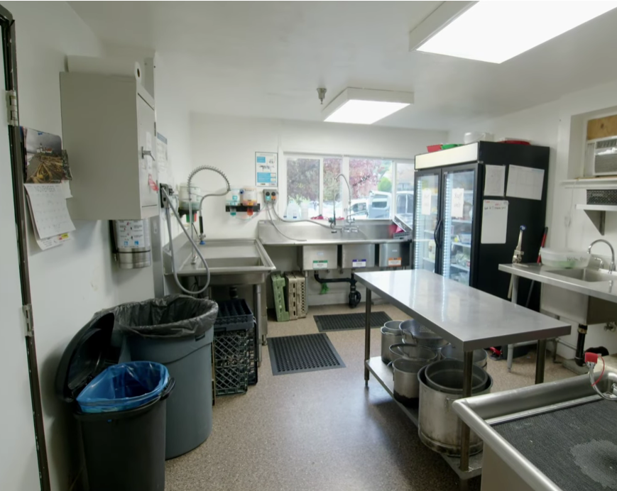 Commercial kitchen with stainless steel tables and sinks
