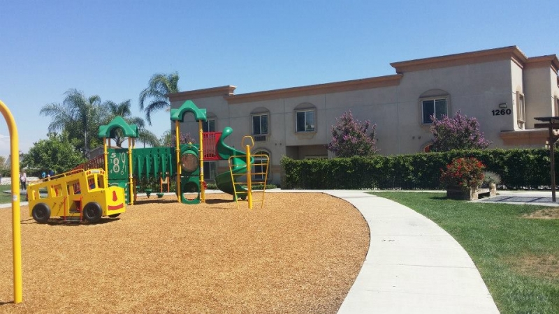 Playground with slide and toy bus outside recovery center building