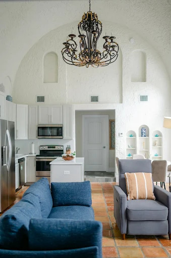Kitchen and lounge area with chandelier and seating.