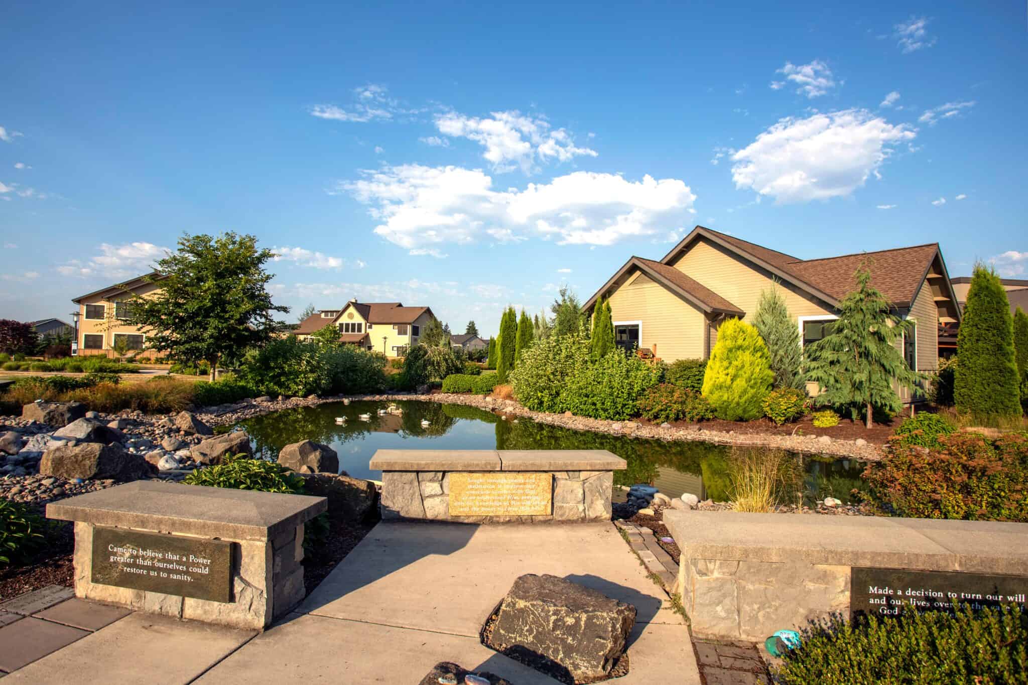 Peaceful pond surrounded by landscaped gardens and cottages