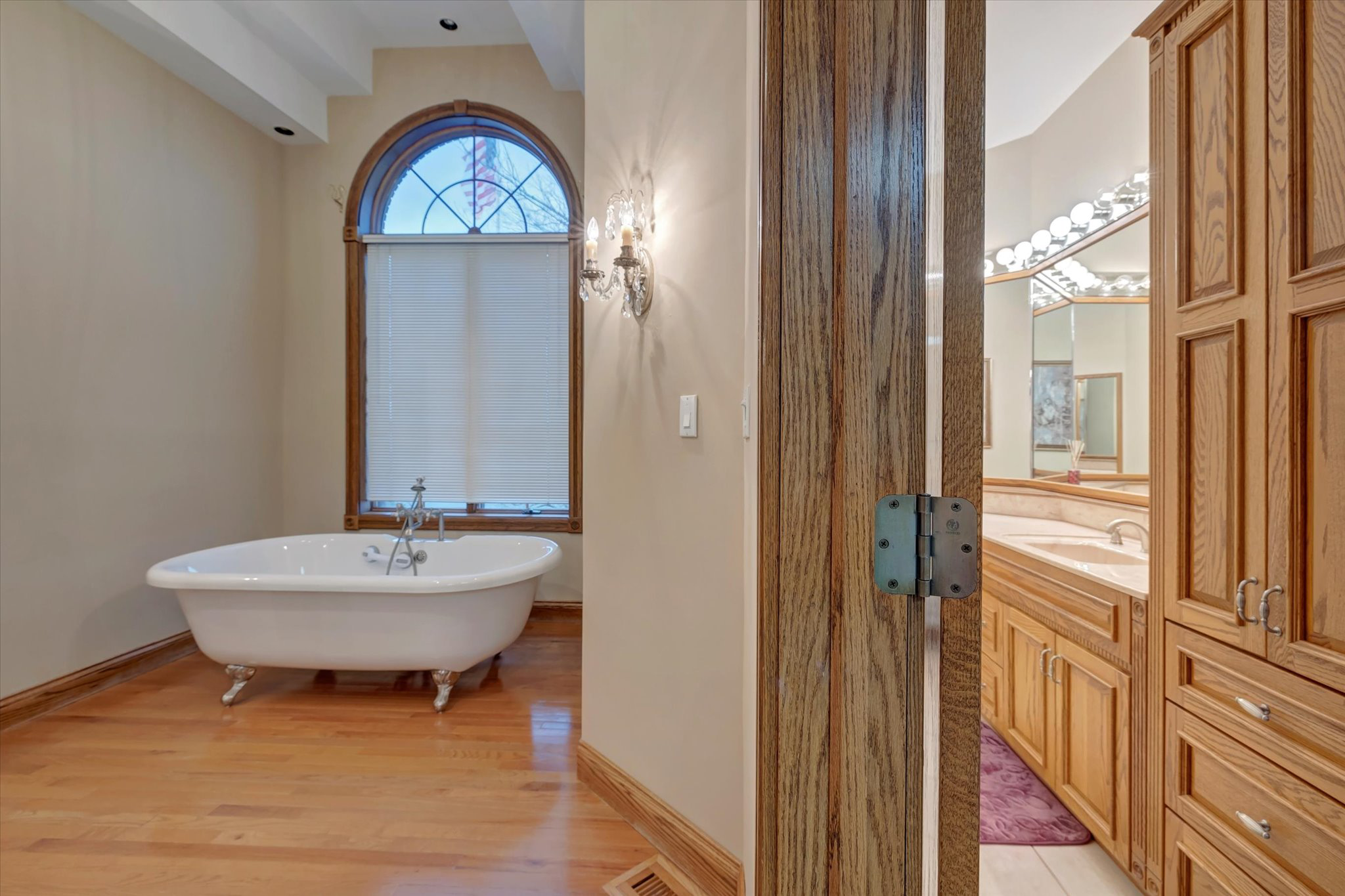 Private bathroom with soaking tub and wood cabinetry