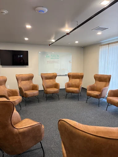 Circle of tan chairs in bright counseling room