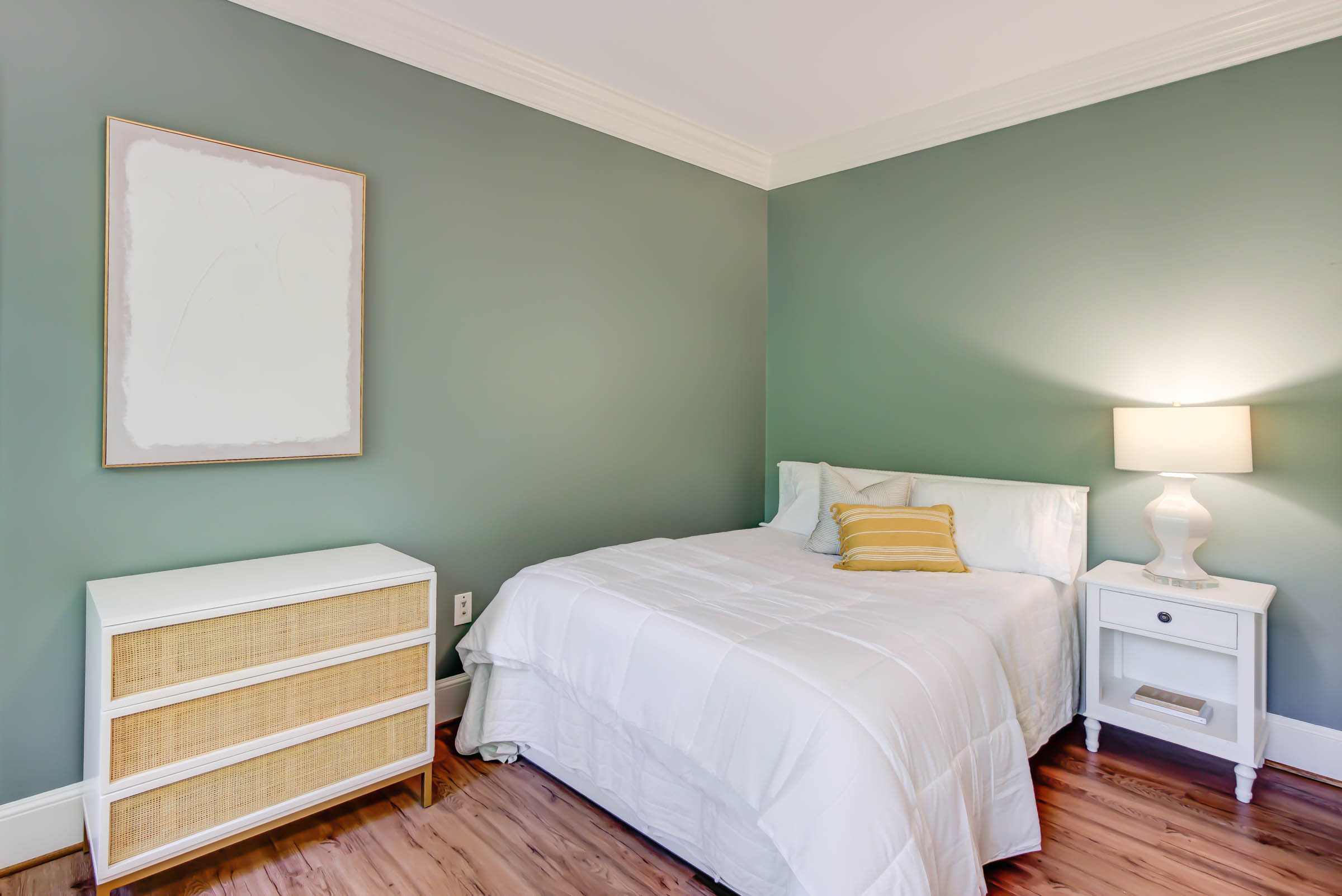 Twin bed with green accent wall and nightstand.