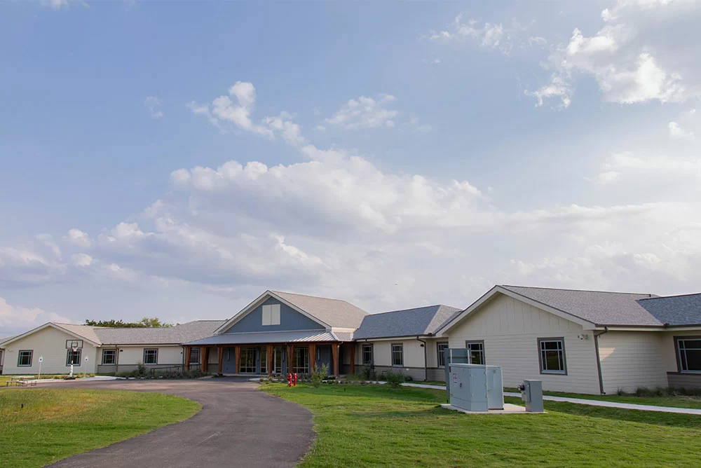Exterior of the facility with a lawn and circular driveway