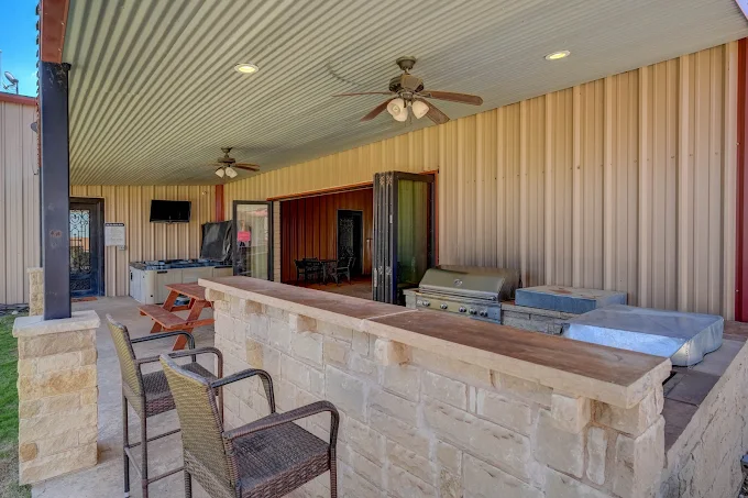 Covered patio with grill, seating, and outdoor kitchen