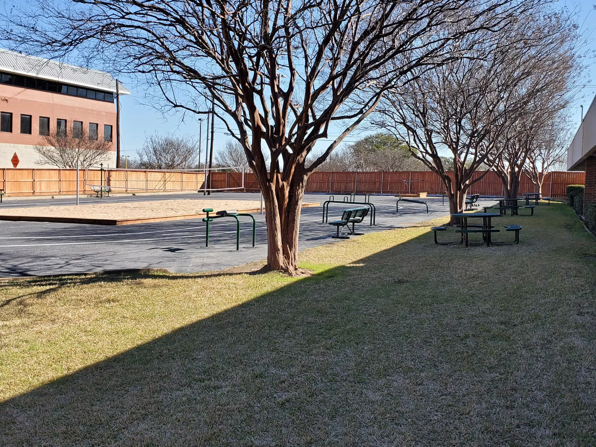 Outdoor area with trees, picnic tables, and open yard space