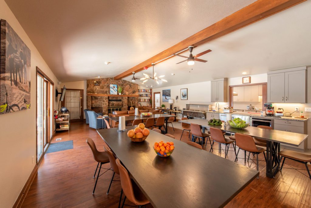Shared dining area with long tables and open kitchen