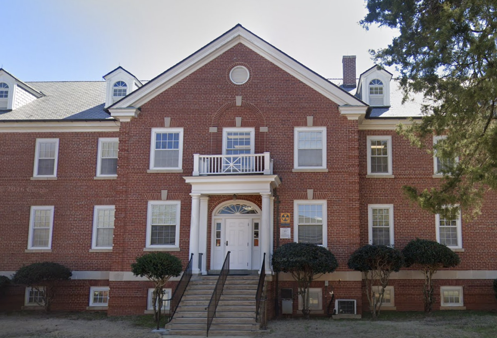 Red brick facility building with white entrance and steps