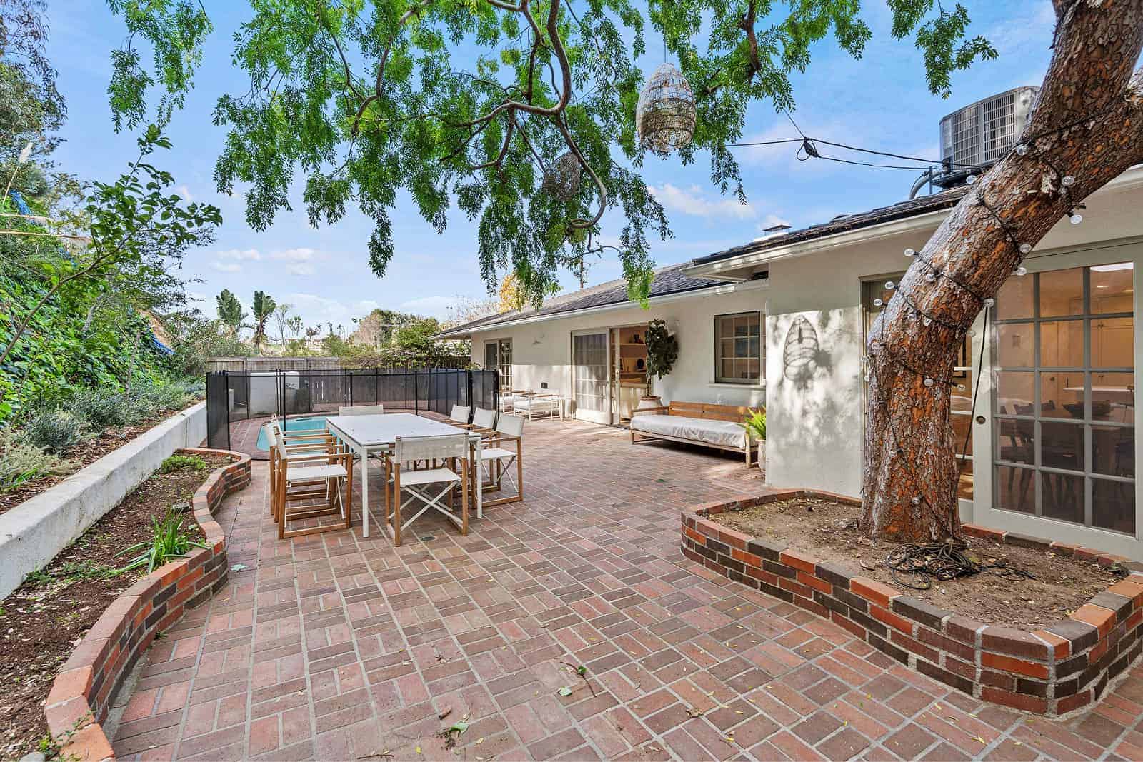 Outdoor patio with seating near fenced pool area