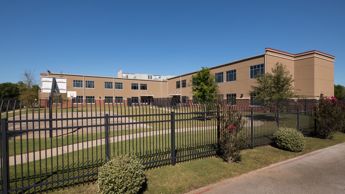 Fenced outdoor recreation area with basketball court