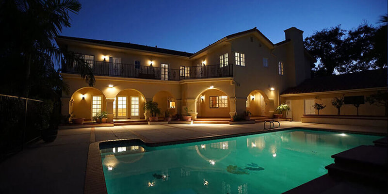 A beautifully lit villa at dusk, featuring a serene pool with glowing water, elegant arches, and a peaceful ambiance under the evening sky.A beautifully lit villa at dusk, featuring a serene pool with glowing water, elegant arches, and a peaceful ambiance under the evening sky.