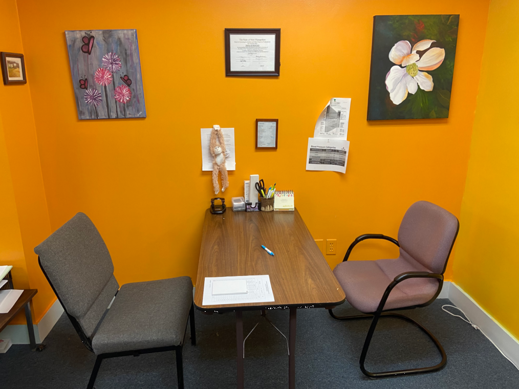 Outpatient counseling office with desk, chairs, and calming artwork