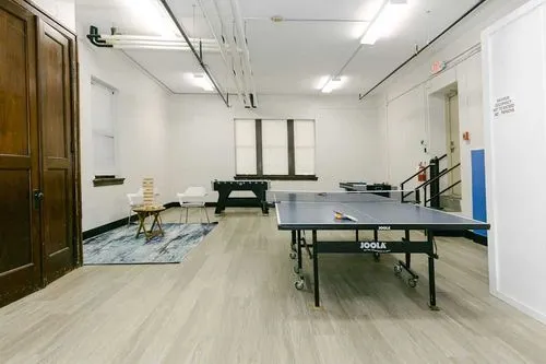Ping pong and foosball tables in a rec room