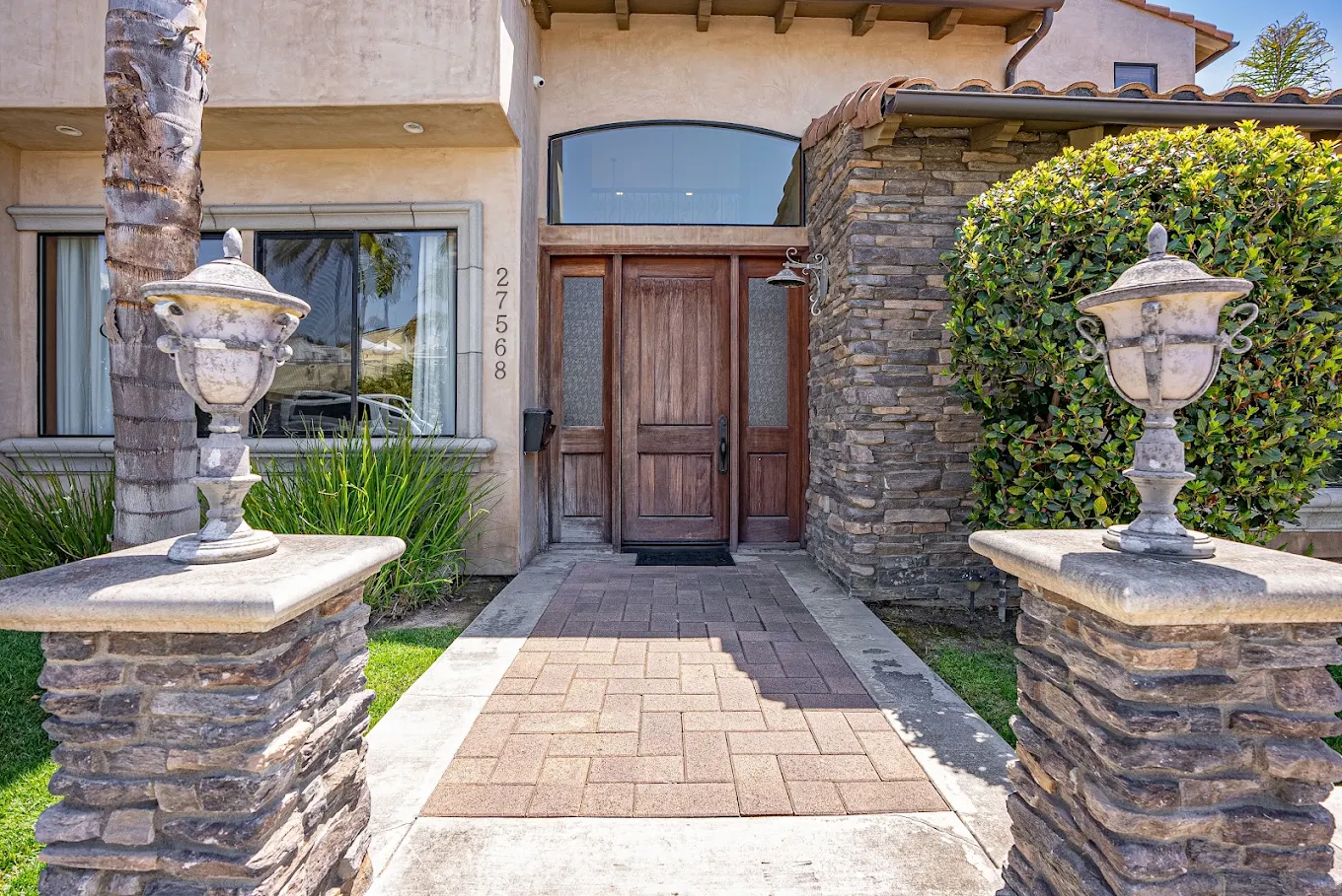 Front entrance with wooden doors and stone pillars
