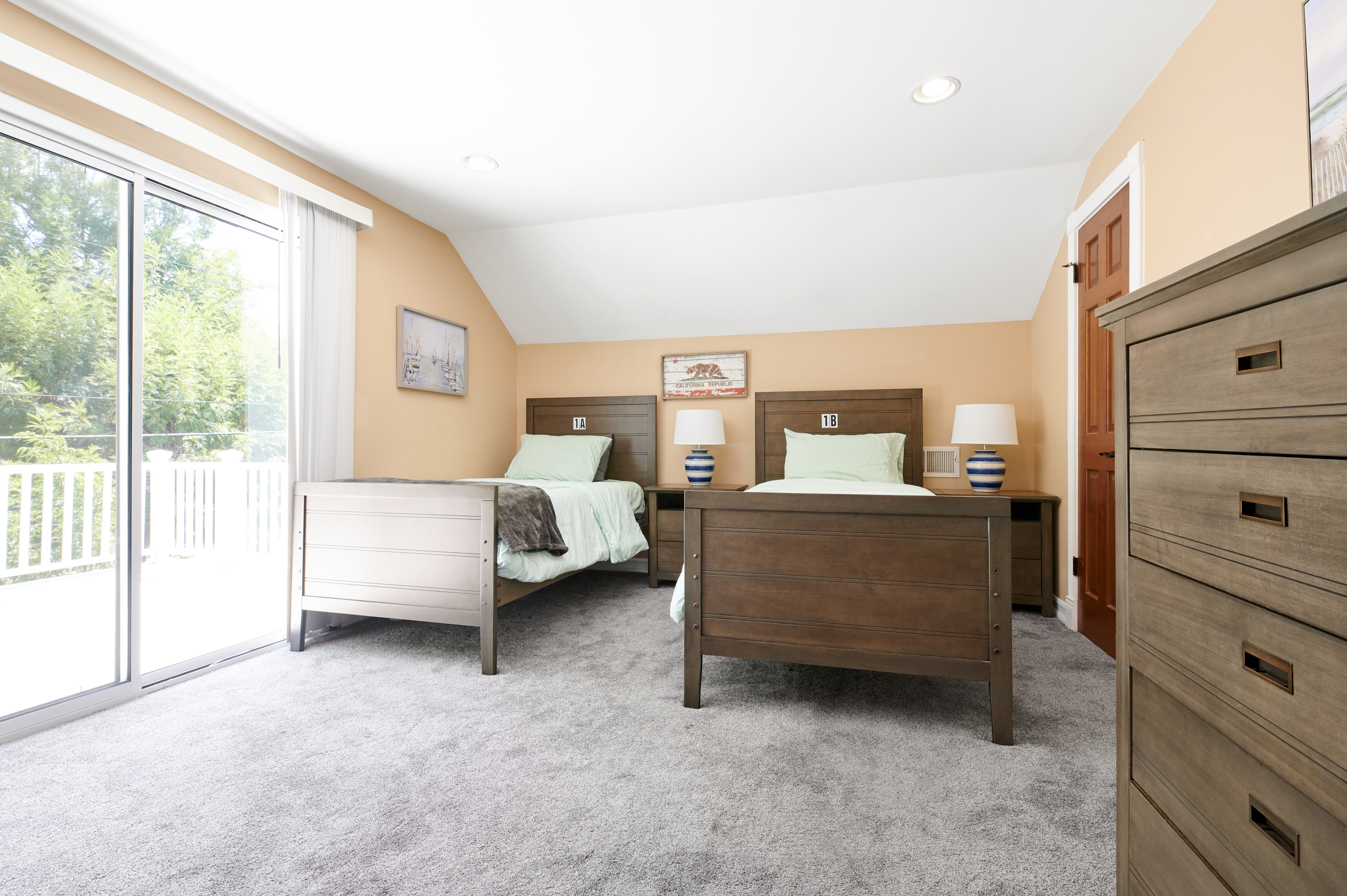 Shared bedroom with twin beds and lamps.