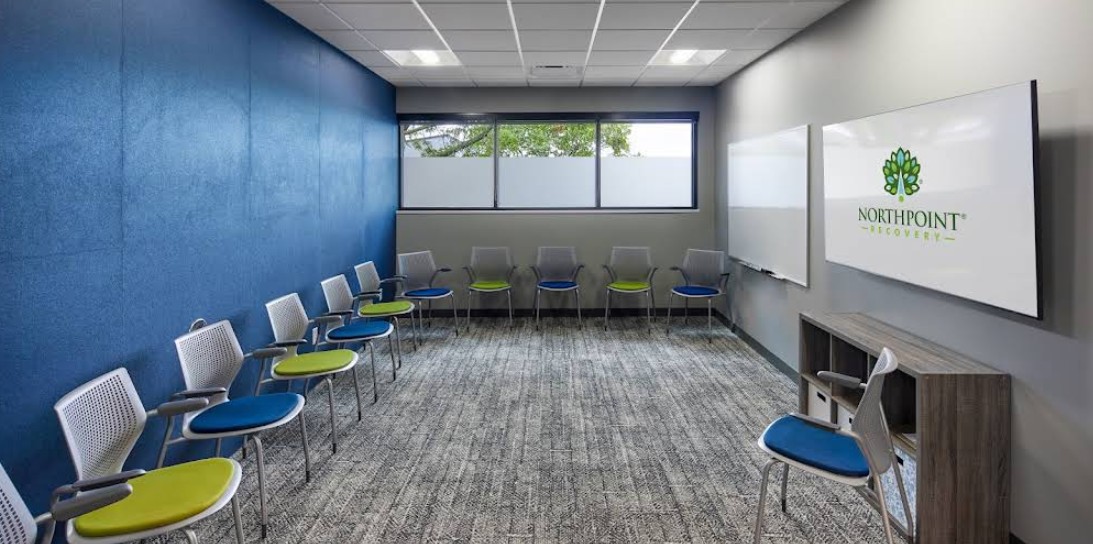 Group therapy room with chairs, whiteboards, and display screen