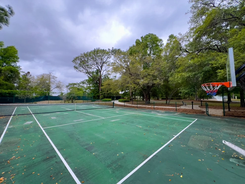 Outdoor tennis and basketball court surrounded by trees on treatment center campus