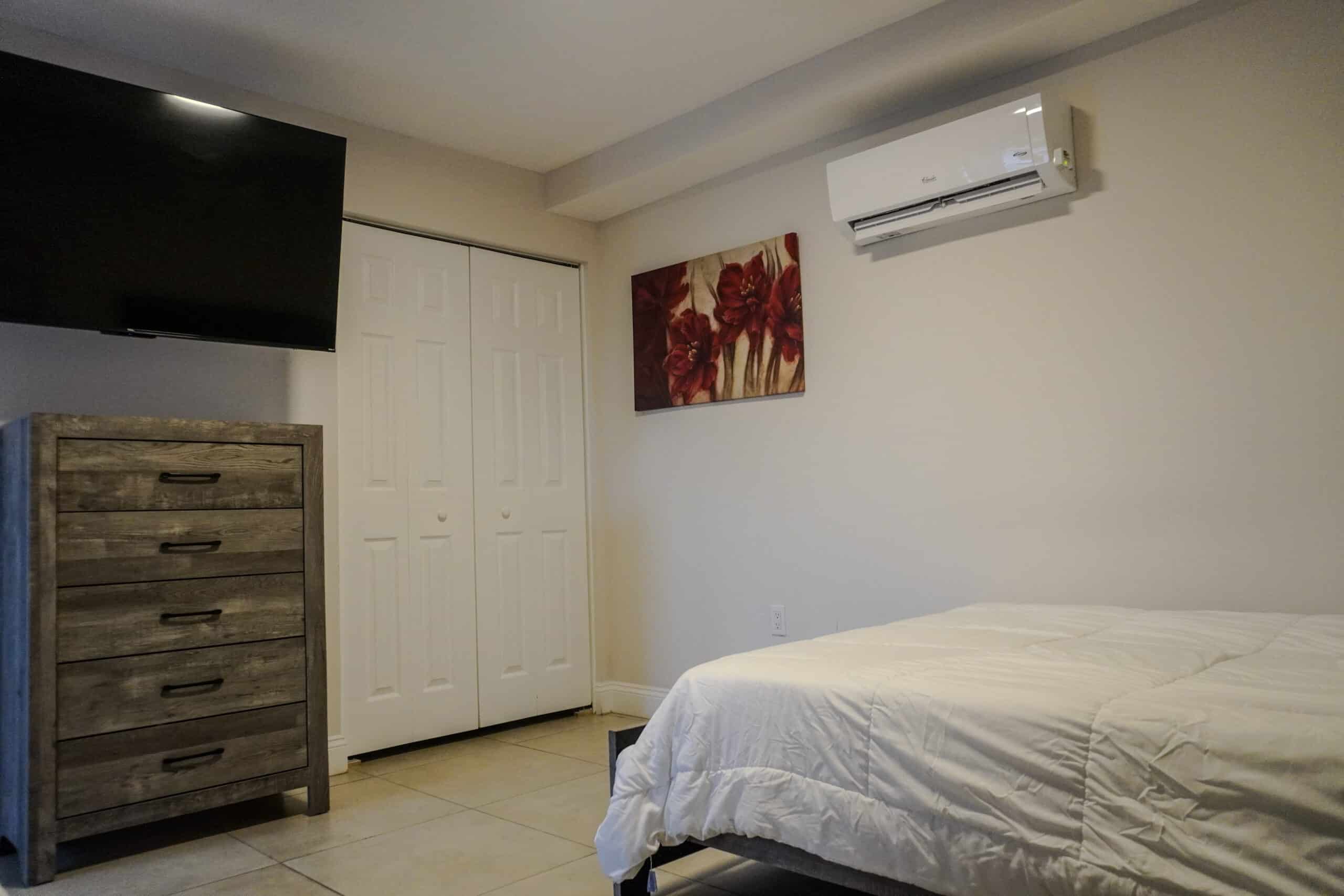 Private room with bed, dresser, TV, and air conditioning