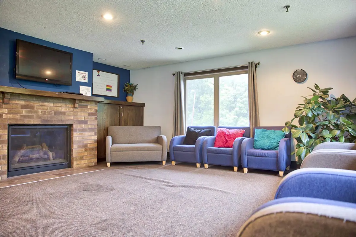 TV lounge with sofas and fireplace for residents