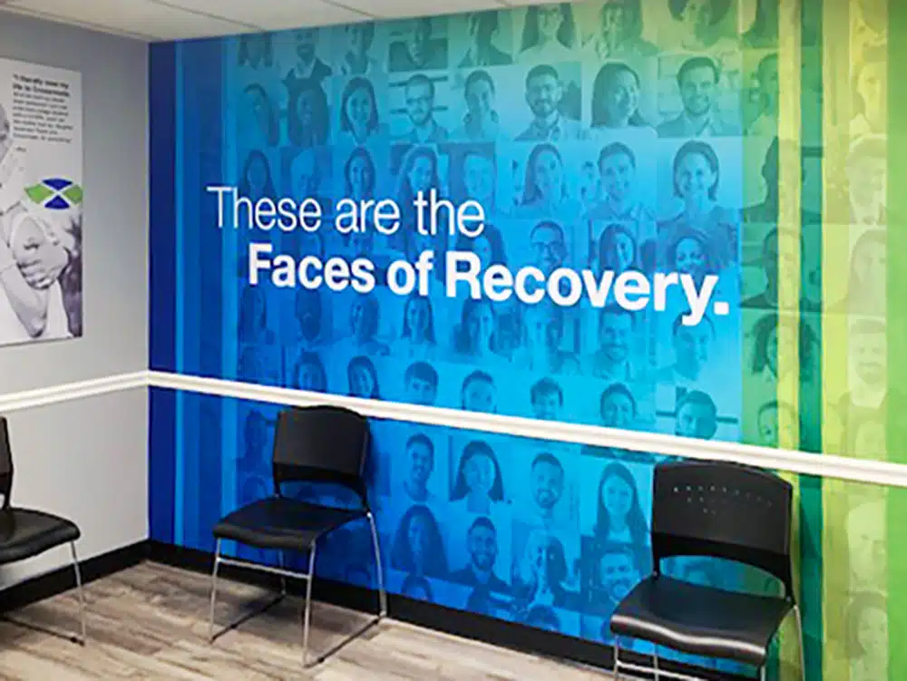 Chairs along wall with colorful Faces of Recovery mural
