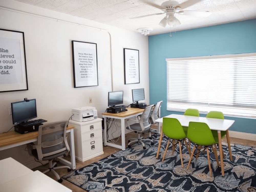 Computer lab with desks, computers, and green chairs