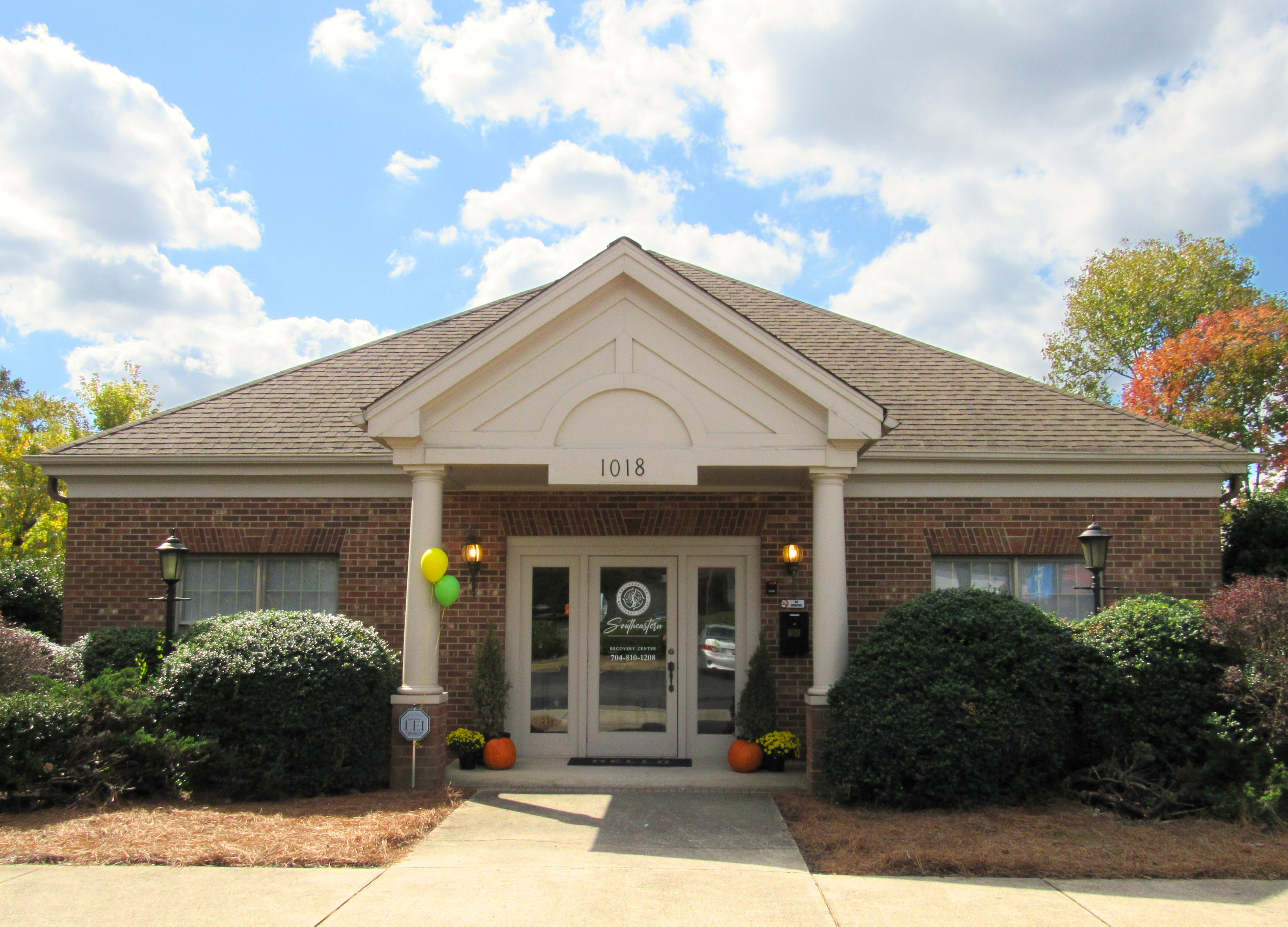Brick building entrance with balloons and pumpkins