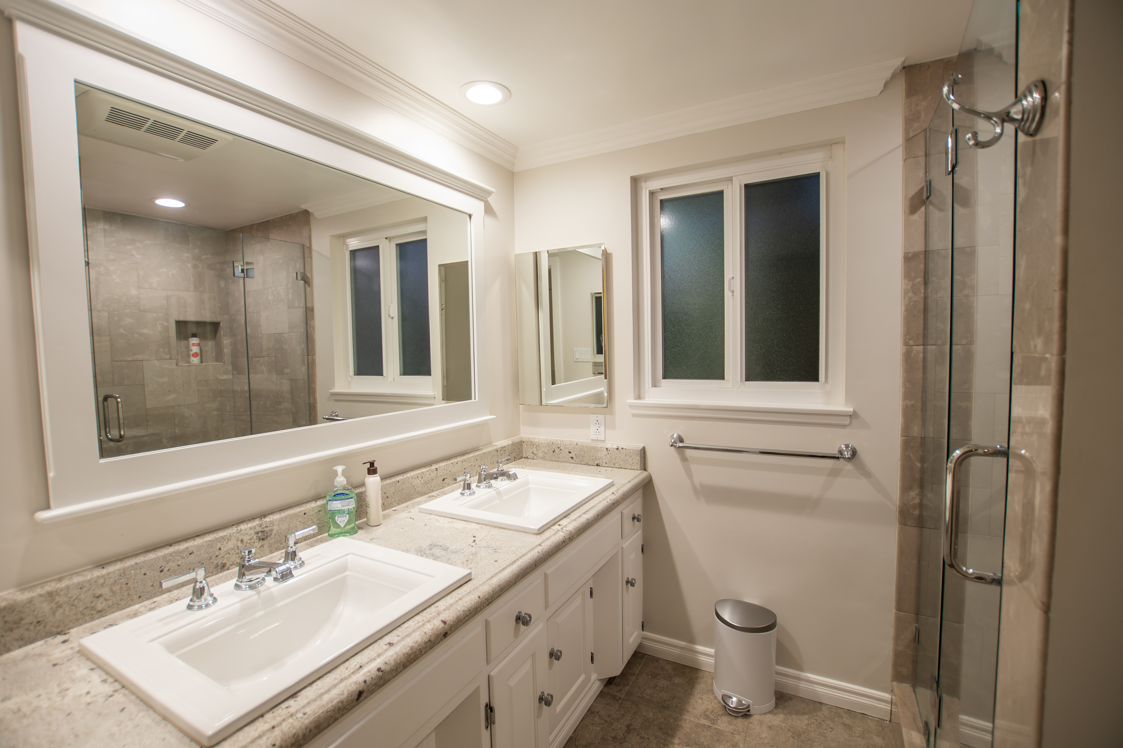 Bathroom with two sinks and a glass shower