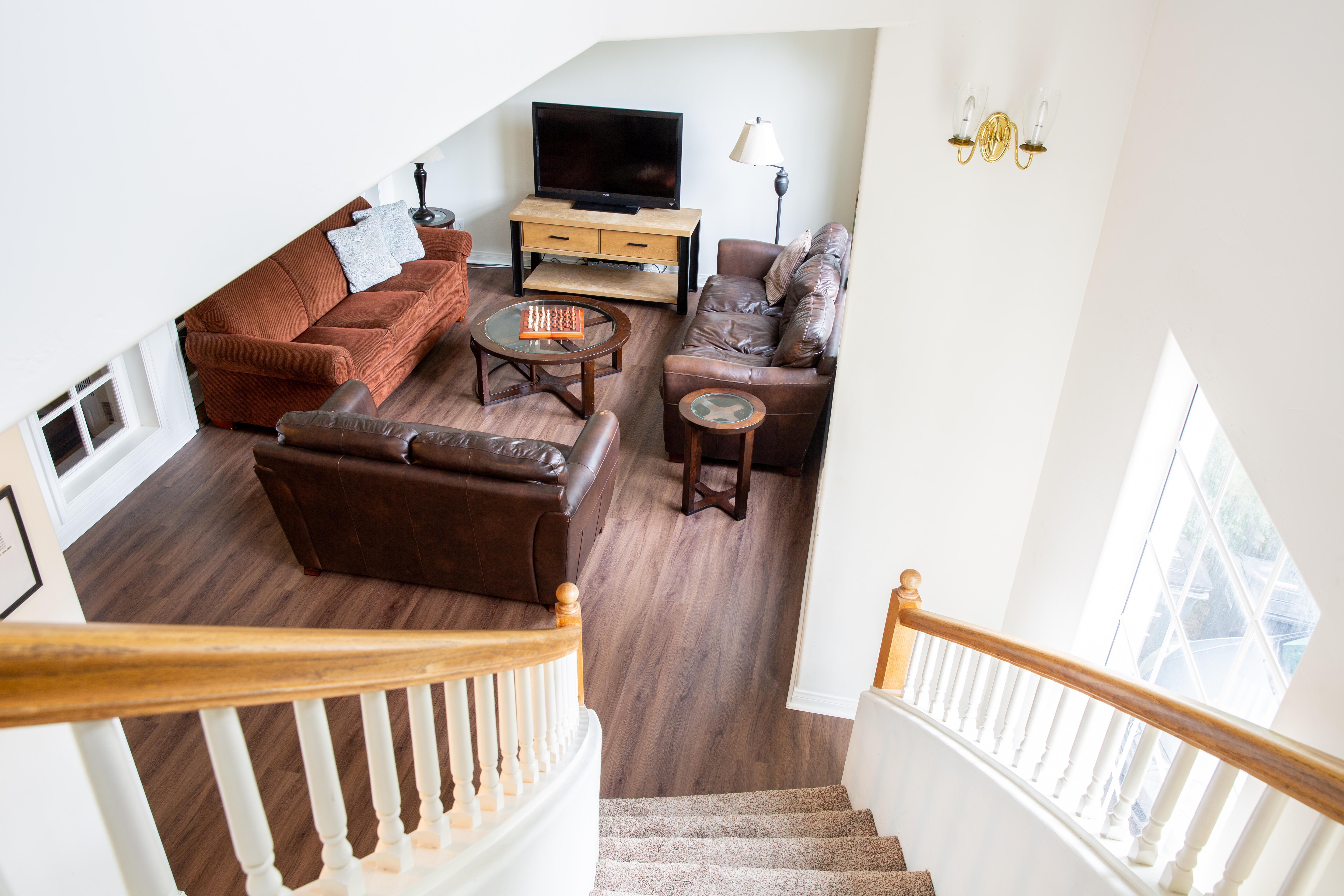 Lounge with sofas and TV at top of carpeted stairs