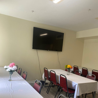 Dining room with tables, chairs, and wall-mounted TV