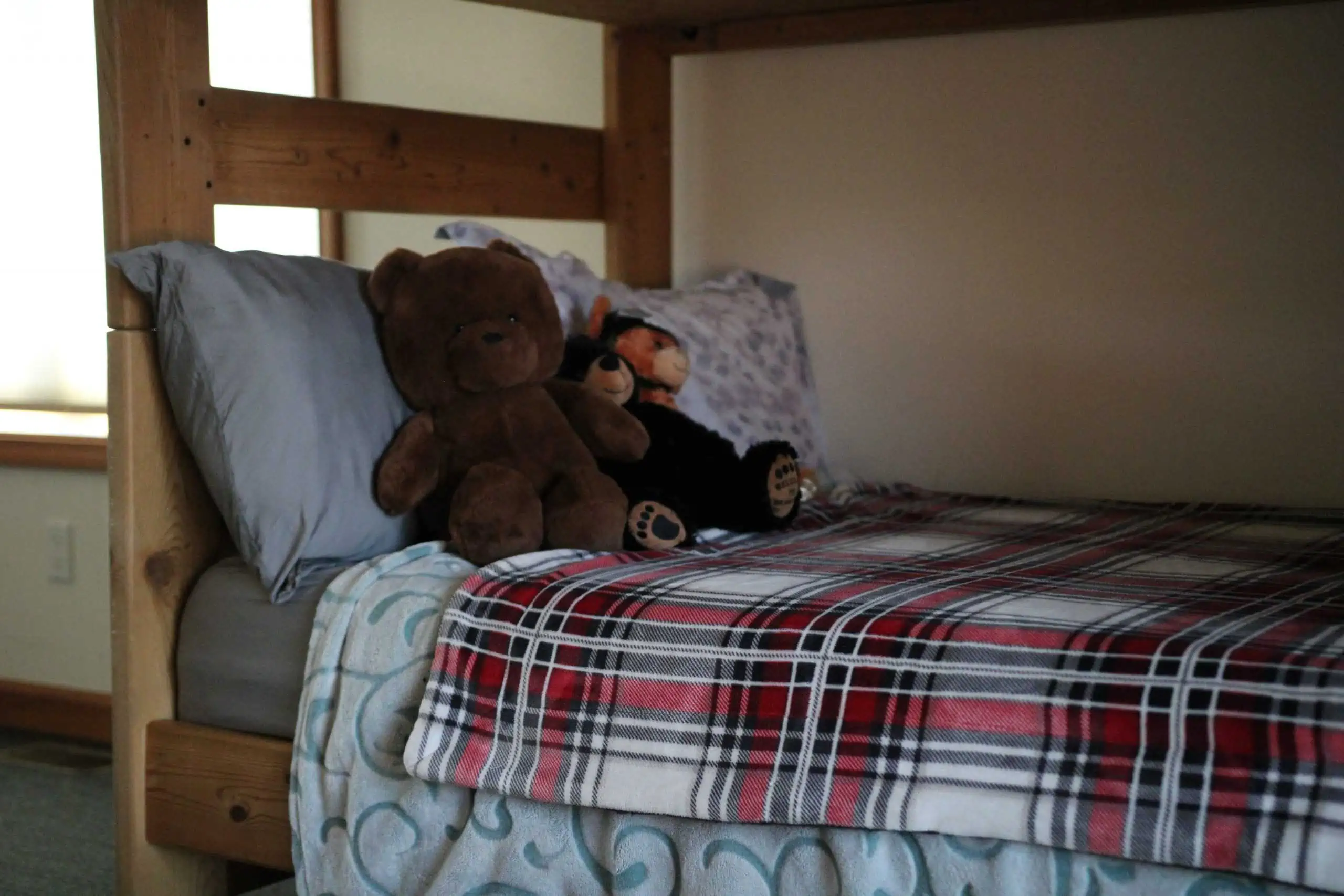 Bunk bed with plaid bedding and teddy bears