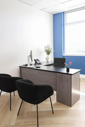 Private office with desk and two black chairs