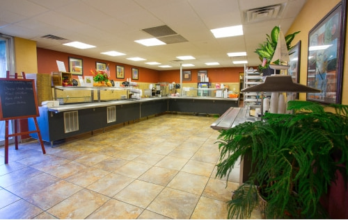 A cafeteria-style dining area with food stations and seating.