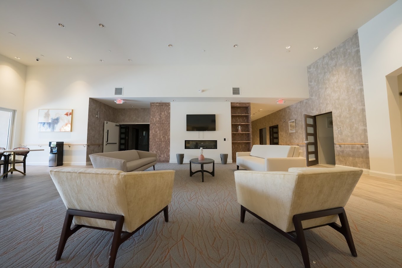 Large common area with neutral-toned furniture and a fireplace.