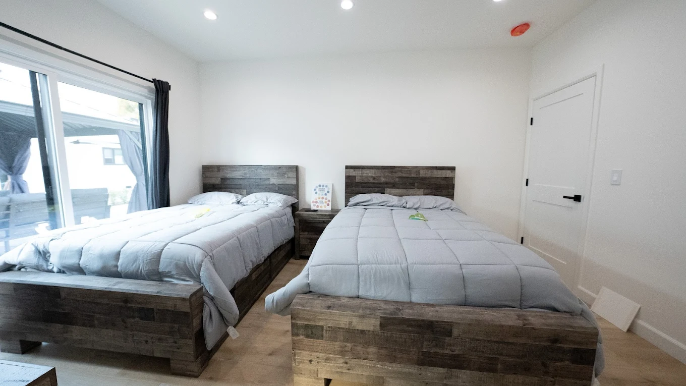 Bedroom with two beds and sliding glass door